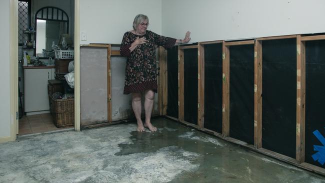 Donna in the flood-damaged lower portion of their home which is still awaiting repair. Picture: Glenn Campbell.