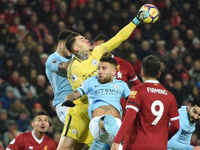 Manchester City's Brazilian goalkeeper Ederson (C) comes out to punch the ball during the English Premier League football match between Liverpool and Manchester City at Anfield.
