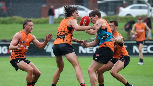 Harry Jones and Kaine Baldwin grapple for the ball on a damp Saturday morning at The Hanger. Picture: Ian Currie