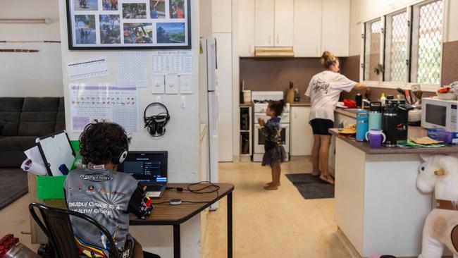 Michelle's son Lui Cooper (7) connecting to 'school of the air' with Shiloh Cooper (4) and Michelle inside their family home at Cobourg Peninsula. Picture: Helen Orr