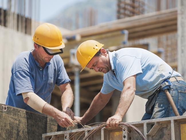 Construction workers working on cement formwork frames