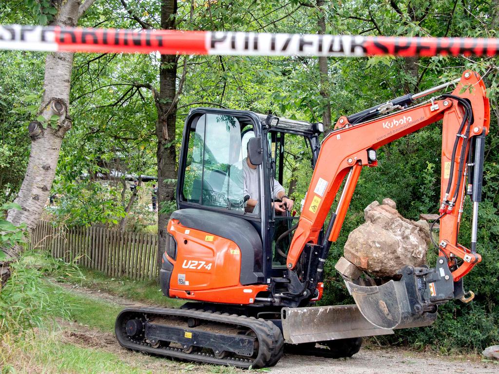 An excavator removes stone as police officers search a garden allotment in the northern German city of Hanover. Picture: Hauke-Christian Dittrich / AFP