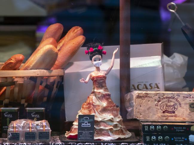 A doll wearing a face mask and dressed in strips of Spanish ham is displayed in a food shop window in Madrid. Picture: AP