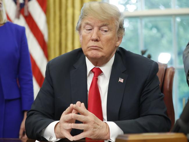 President Donald Trump listens to Vice President Mike Pence speak before signing an executive order to end family separations at the border.