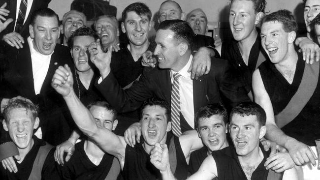 Essendon celebrates a victory in 1959. Ian ‘Bluey’ Shelton is pictured front row on the left. The players are (from left) Back: Alby Murdoch, Hugh Mitchell, Dick Reynolds (coach), Brian Sampson, Colin Hebard, John Towner (half hidden). David Shaw. Front: Ian Shelton, Ken Fraser, Alec Epis, Barry Capuano, Graham Leydin. Picture: George Bugden.