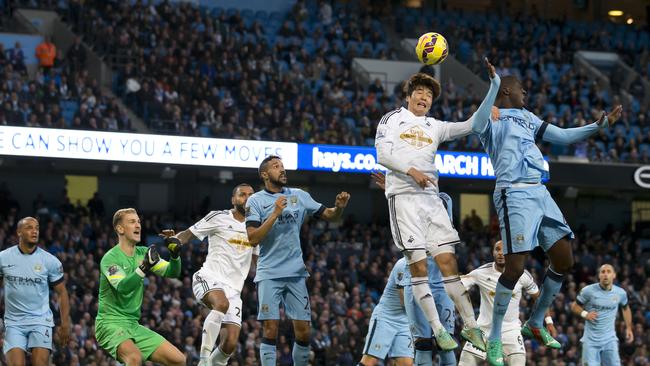 Manchester City's Yaya Toure, upper right, jumps for the ball against Swansea's Ki Sung-Yeung.