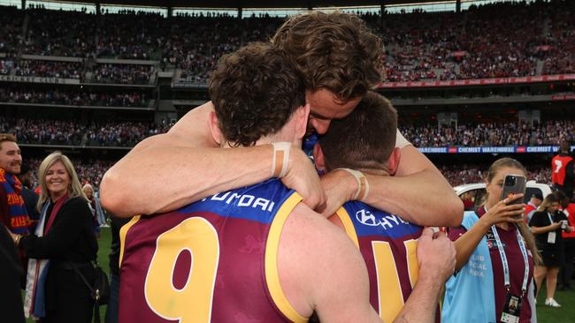 Lachie Neale (left), Joe Daniher (centre) and Dayne Zorko embrace after Brisbane’s grand final win over Sydney. Picture: Lachie Millard