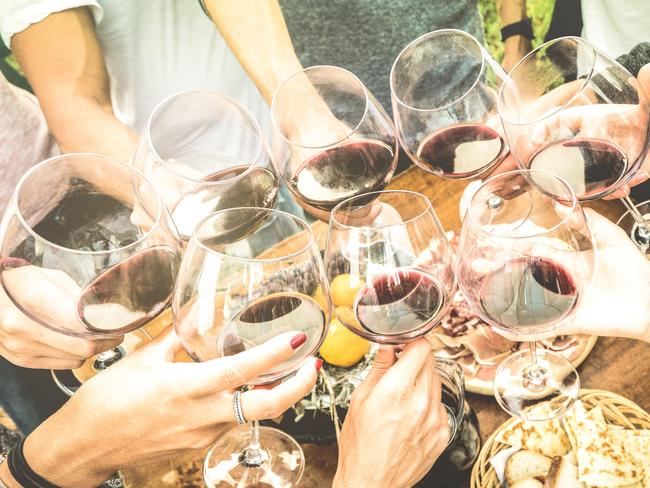 Friends hands toasting red wine glass and having fun outdoors cheering with winetasting. Picture: iStockKerry Heaney, Escape, How to plan a holiday with friends