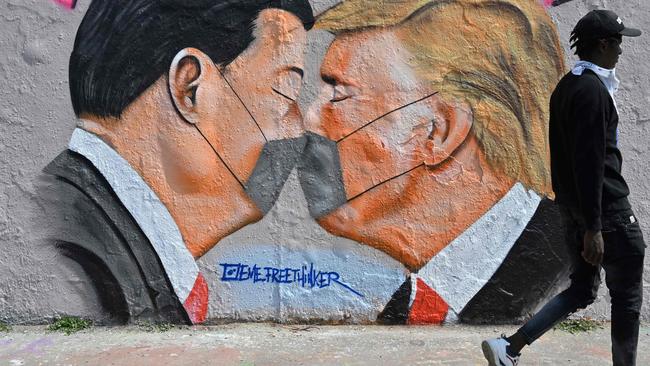 A mural painting by graffiti artist Eme Freethinker features kissing US President Donald Trump and Chinese premier Xi Jinping wearing face masks, in Berlin this week. Picture: AFP