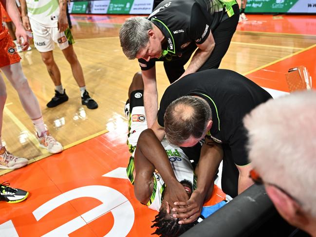 Phoenix head coach Mike Kelly attends to an injured Tyler Cook. Picture: Emily Barker/Getty Images