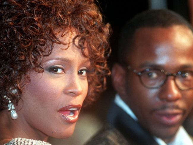 13/10/1997 WIRE: FILE - In this Oct. 13, 1997 file photo, Whitney Houston looks over her shoulder as her husband Bobby Brown looks to her at the premiere of "The Wonderful World of Disney" movie "Cinderella," at Mann's Chinese Theater in the Hollywood section of Los Angeles, Whitney Houston, who reigned as pop music's queen until her majestic voice and regal image were ravaged by drug use, has died, Saturday, Feb. 11, 2012. She was 48. (AP Photo/Rene Macura, File)