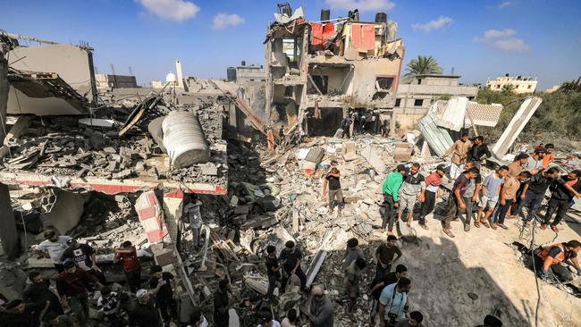 People gather by the rubble of a building that collapsed after Israeli bombardment while searching for survivors and the bodies of victims. Picture: AFP