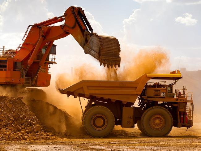 A haul truck is loaded by a digger with material from the pit at Rio Tinto Group's West Angelas iron ore mine in Pilbara, Australia, on Sunday, Feb. 19, 2012. Rio Tinto Group, the world's second-biggest iron ore exporter, will spend $518 million on the first driverless long-distance trains to haul the commodity from its Western Australia mines to ports, boosting efficiency. Photographer: Ian Waldie/Bloomberg via Getty Images