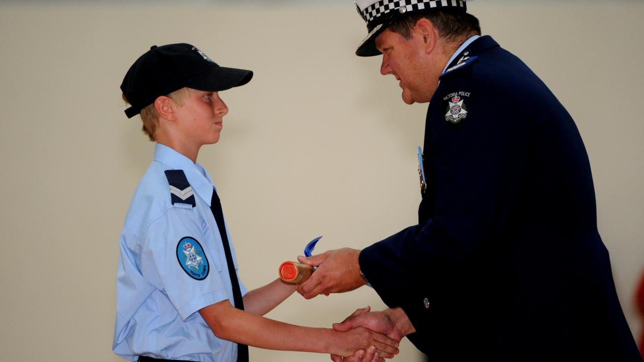 Assistant Commissioner Luke Cornelius congratulates Mornington Secondary College police youth corps graduates dux Alex Jaeger in 2012.