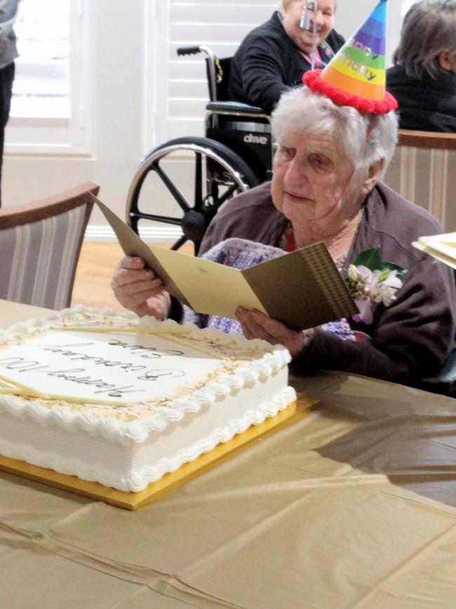 Elva Larsen reads her card from the Queen.