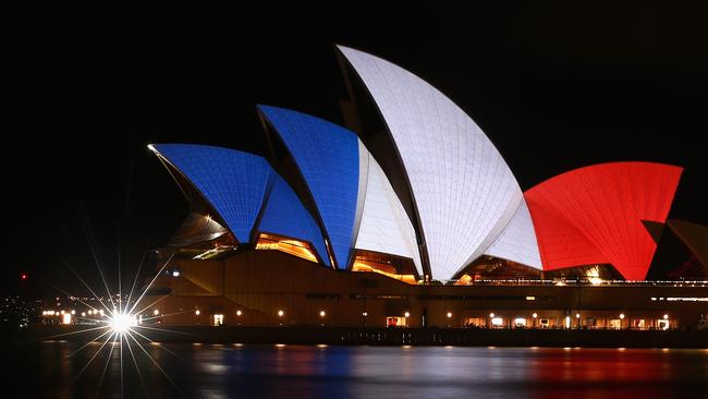 The sails of the Sydney Opera House are illuminated in the colours of the French flag. Picture: Cameron Spencer / Getty Images