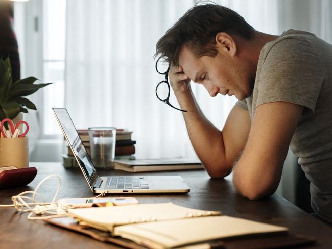 Man stressed while working on laptop