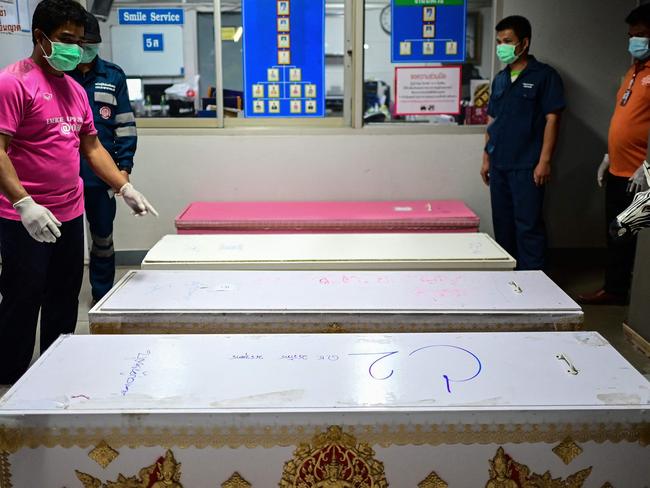 A hospital staff points to a coffin believed to be carrying the body of gunman Panya Khamrab at the hospital morgue in Udon Thani. Picture: AFP