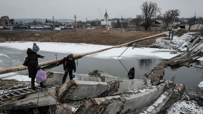 People pick their way over a destroyed bridge in the frontline Ukrainian town of Bakhmut this week. Picture: AFP