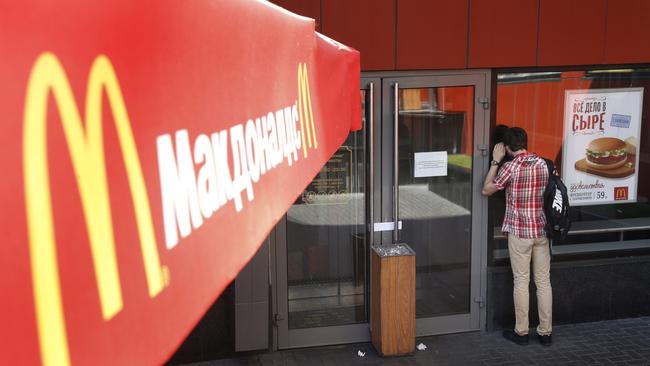 A man looks through the window at the entrance of a closed branch of McDonald's in Moscow.