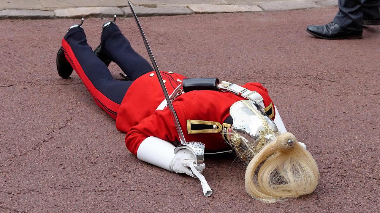 The soldier collapsed in the heat. Picture: Kirsty Wigglesworth/Pool/AFP