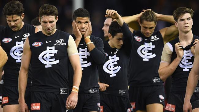 Carlton players walk off after losing a game.