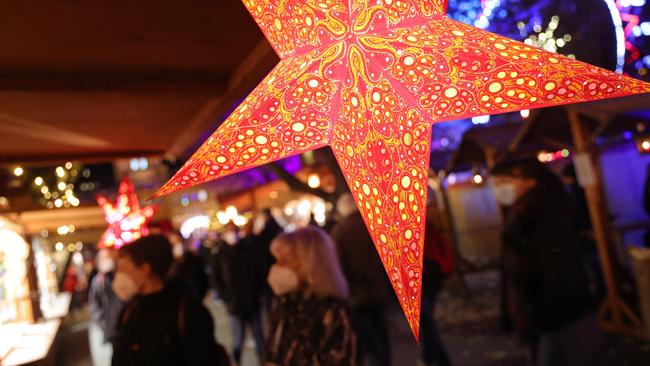 Masked visitors at a Christmas market at Alexanderplatz in Berlin, Germany. Picture: Getty Images