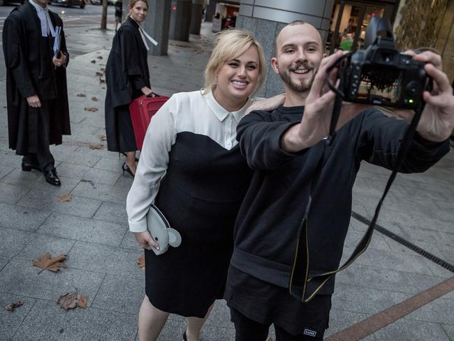 Rebel Wilson takes a selfie taken with a fan after leaving the Supreme Court. Picture: Jake Nowakowski.