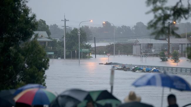 People out looking at the rising flood water of the Hawkesbury River as it flows over the New Windsor Bridge. Picture: Damian Shaw