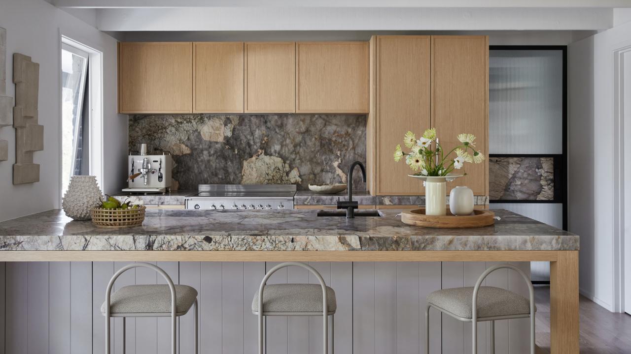 The kitchen is fitted with striking stone benchtops and splashbacks.