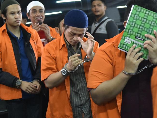 Ali Makhmudin (blue cap) arrives at the court with other terror suspects to hear the judges' verdict in Jakarta on October 25, 2016. Makhmudin was found guilty of breaking anti-terror laws for helping prepare bombs used in the attack in the heart of the Indonesian capital in January, which killed four civilians and four attackers. An Indonesian court jailed an Islamic State group supporter for eight years for his role in a deadly gun and suicide attack in Jakarta, the latest extremist sentenced over the assault. / AFP PHOTO / BAY ISMOYO