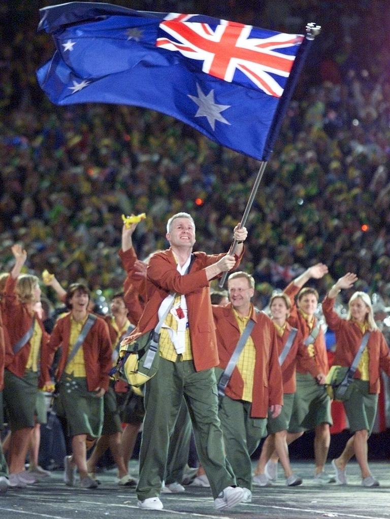##AFP PIC FEE PAYABLE CHECK BEFORE USE## Basketball player Andrew Gaze carries the Australian flag as he marches with his team 15 Sept 2000 during the Athletes Parade in the opening ceremony of the 2000 Olympic Games. picTIMOTHY/CLARY sport  olympics olympic2000 /Sydney flags sydney2000