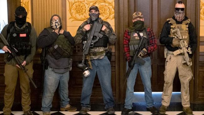 Protesters posing for photos outside Michigan Governor Gretchen Whitmer’s office.