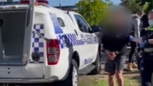 One of the men arrested in Roxburgh Park is led to a police vehicle.