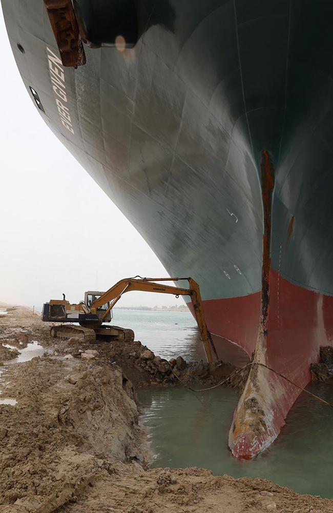 In an epic mismatch, this digger is trying to dislodge the mega ship. Picture: Suez Canal Authority/AFP