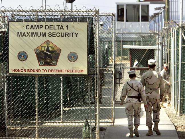 In this June 27, 2006 file photo, reviewed by a U.S. Department of Defense official, U.S. military guards walk within Camp Delta military-run prison, at the Guantanamo Bay U.S. Naval Base, Cuba. (AP Photo/Brennan Linsley, File)