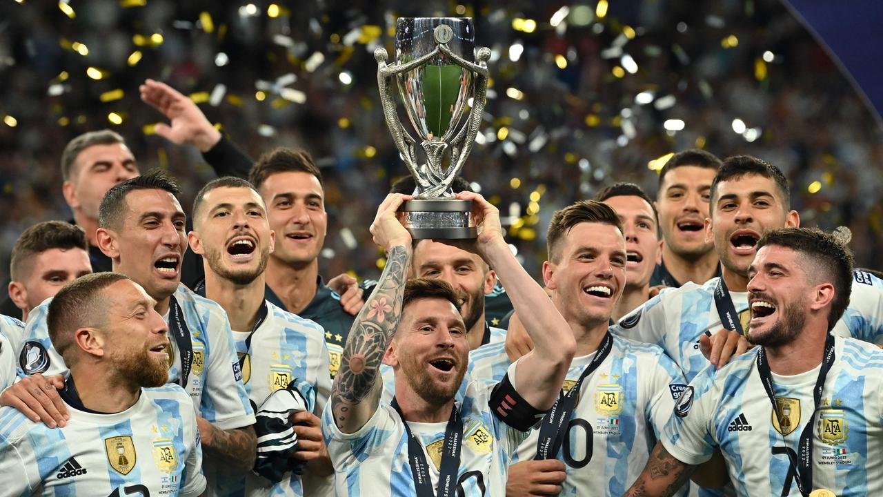Argentina's striker Lionel Messi lifts the trophy as Argentina's players celebrate on the pitch after their victory in the 'Finalissima' International friendly football match between Italy and Argentina at Wembley Stadium in London on June 1, 2022. – The Azzurri face the South American continental champions in the inaugural Finalissima at Wembley. (Photo by Glyn KIRK / AFP)