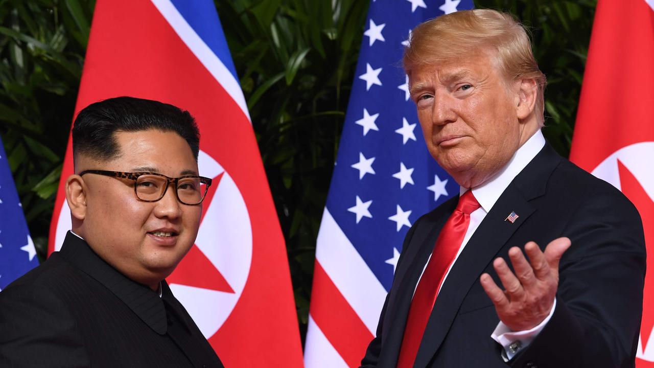 US President Donald Trump (R) gestures as he meets with North Korea's leader Kim Jong Un (L) at the start of their historic US-North Korea summit, at the Capella Hotel on Sentosa island in Singapore on June 12, 2018. Donald Trump and Kim Jong Un have become on June 12 the first sitting US and North Korean leaders to meet, shake hands and negotiate to end a decades-old nuclear stand-off. / AFP PHOTO / SAUL LOEB