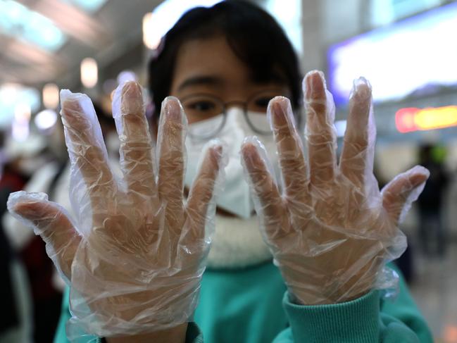 A South Korean teenager wearing plastic glove at the Incheon International Airport in Incheon, South Korea, to protect herself from the deadly coronavirus. Picture: Chung Sung-Jun/Getty