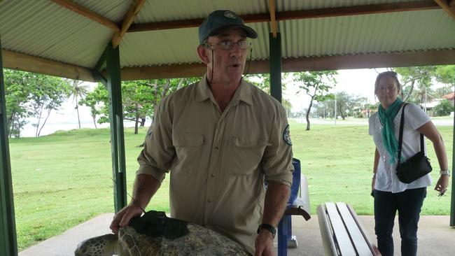 Queensland Parks and Wildlife Senior Conservation Officer Dr Ian Bell with green sea turtle Peanut, about to be released with a satellite tracking device fitted.