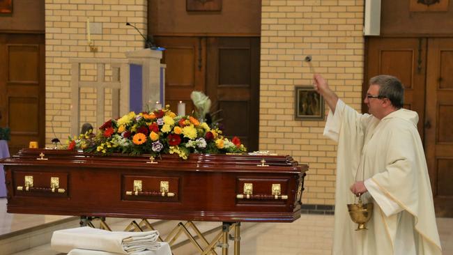 Father Nathan McKay blesses the casket of celebrated Cairns businessman Mario Calanna at a funeral service held on Tuesday at Saint Monica's Cathedral. Picture: Peter Carruthers