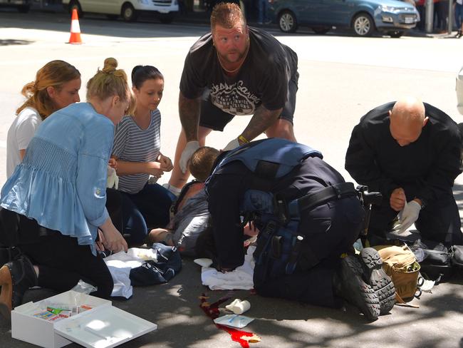 People pitch in to help the injured. Picture: Tony Gough