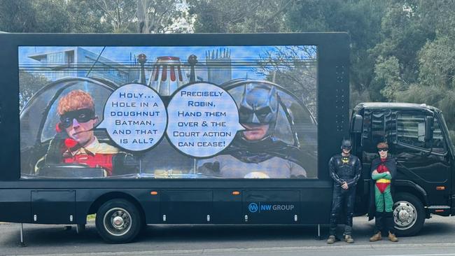 A trailer featuring superheroes is outside Air Apartments, where residents are fighting the community corporation in court over $17m in cladding replacement work. Picture: Supplied