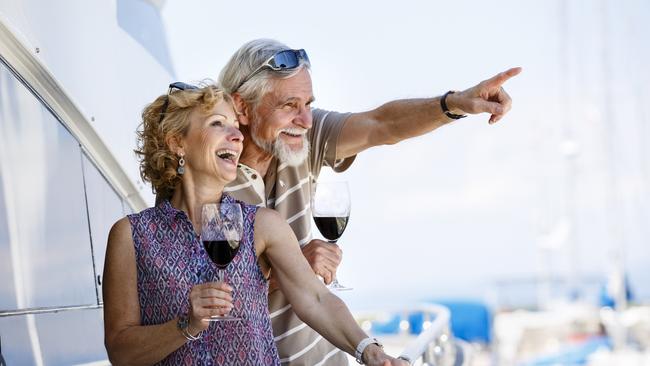 Happy senior couple enjoying wine on yacht. seniors and retirees travel, holidays, generic