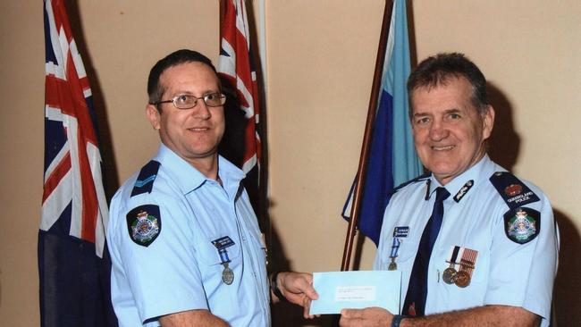 Adrian Zori (left) receives a 25 year clasp Police Service medal from Assistant Commissioner Colin McCallum in 2010.