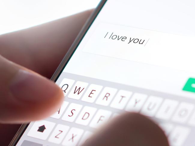 Sending I love you text message with mobile phone. Online dating, texting or catfishing concept. Romance fraud, scam or deceit with smartphone. Man writing comment. Fake profile. Internet safety. Picture: iStock.