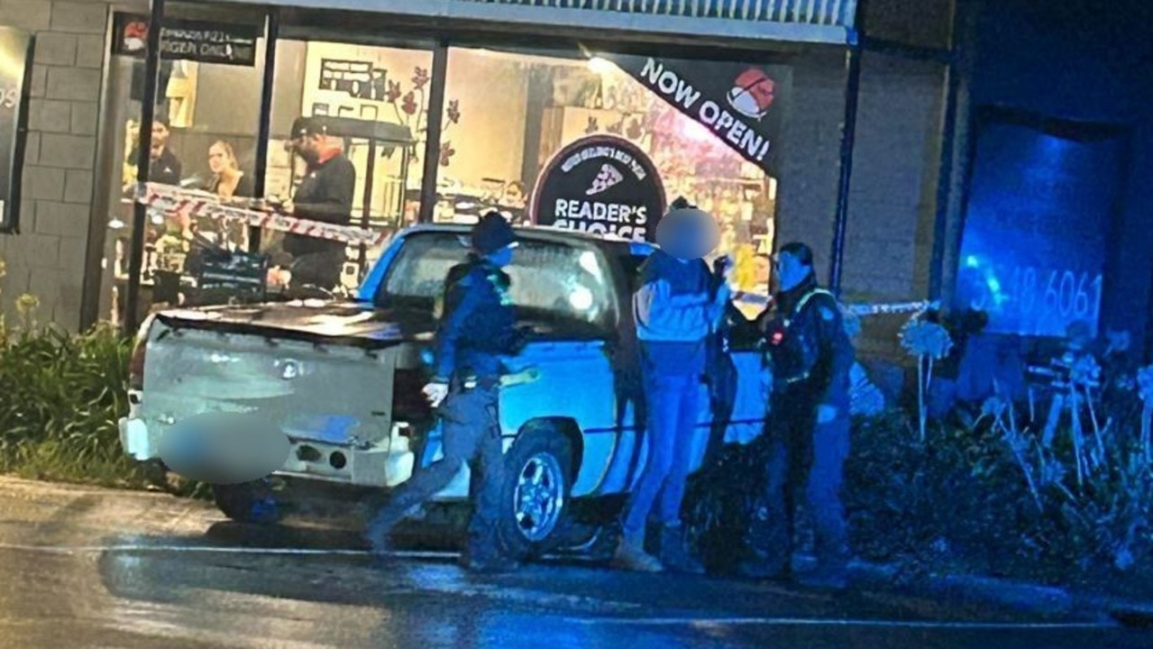 A woman speaks to police after a ute crashed into a Newcomb pizza shop on Tuesday night. Photo: Supplied.