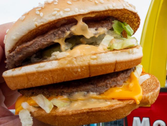 (FILES) In this file photo taken on August 10, 2015 a McDonald's Big Mac, their signature sandwich is held up near the golden arches at a McDonalds's, in Centreville, Virginia. - McDonald's, home of the Big Mac, reported a dip in third-quarter profit on October 23, 2018, but notched comparable sales growth in key regions, including Britain, France and Japan. Net income at the fast-food giant fell to $1.6 billion, a drop of 13.1 percent from the same period of the prior year. But the 2017 quarter was boosted by about $850 million from the sale of businesses in China and Hong Kong. (Photo by Paul J. RICHARDS / AFP)