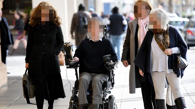 The accused shooter, in wheelchair, outside court with supporters. None of those involved can be identified. Picture: AAP / Mark Brake