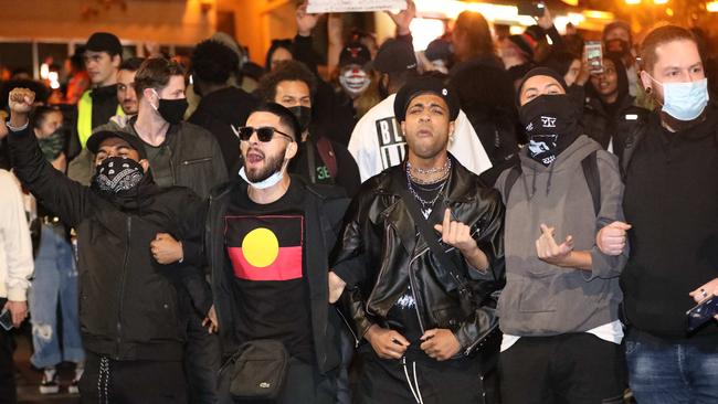 Protesters walk peacefully arm in arm during the rally. Picture: Damian Shaw